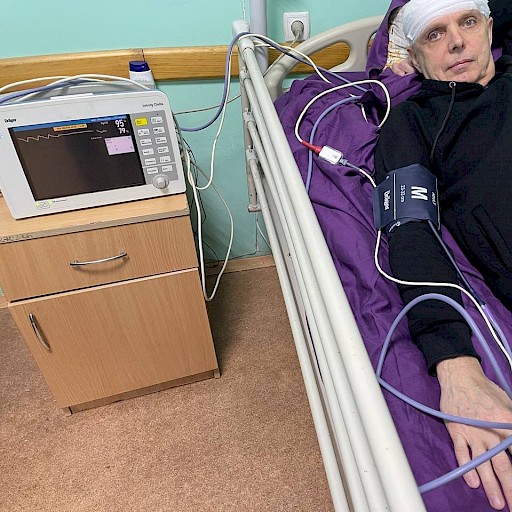 Patient mit Kopfverband an einem gespendeten Monitor.